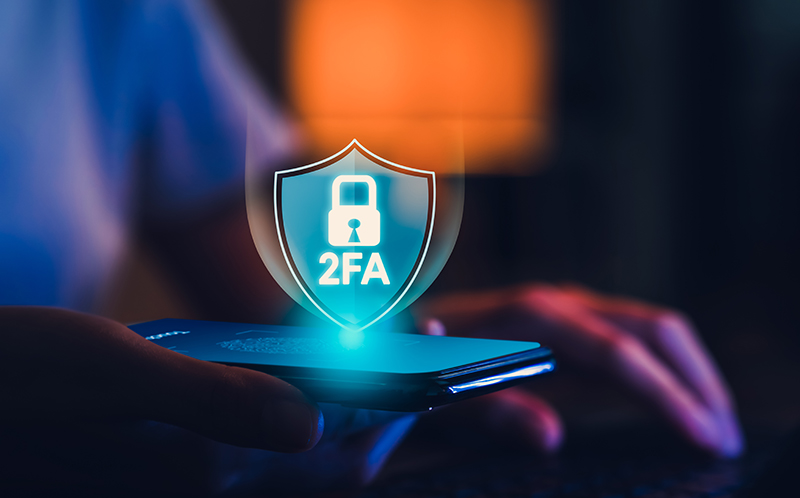 Person holding smartphone with 2FA Lock Icon in middle of screen.