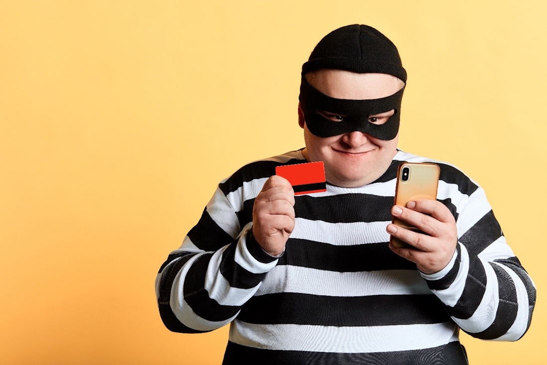 guy dressed in jumpsuit holding credit card