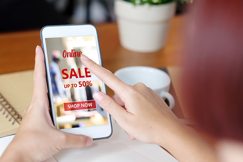 Person scrolling smartphone and shopping online