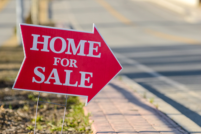 Red Home For Sale Sign Along the Street