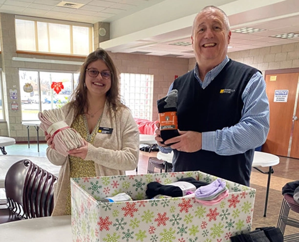 Two Isabella Bank employees collecting items for a community sock drive