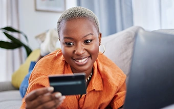 woman shopping online with her laptop and credit card in the living room