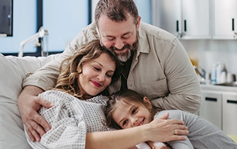 A family of 3 hugging
