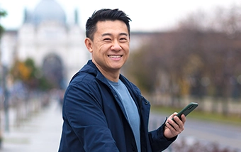 traveling man smiling using mobile device