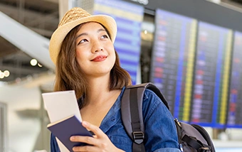 young asian woman exploring the airport as she waits for her flight to dream destination