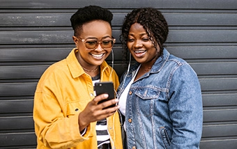Two happy women looking at a phone