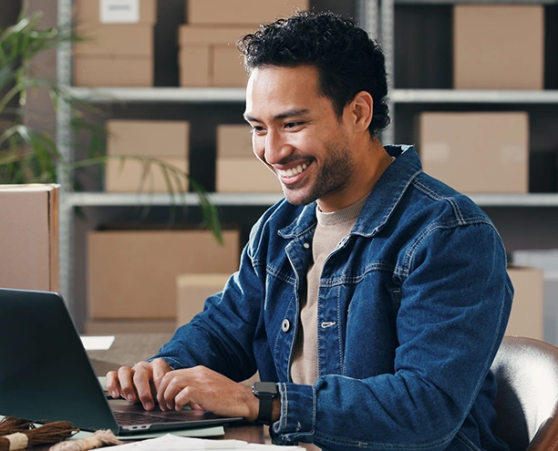 smiling business owner scheduling bill payments from his office