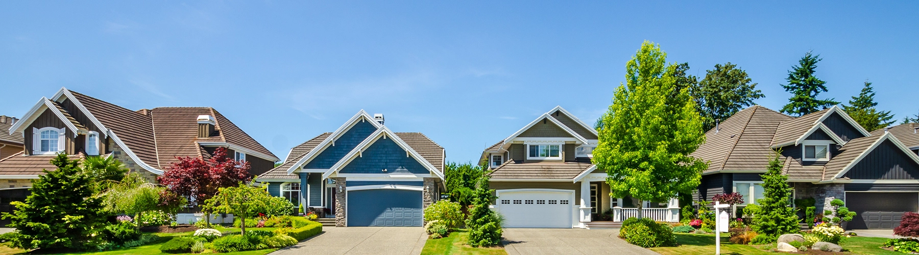Wide angle shot of four the front facade of four typical suburban homes