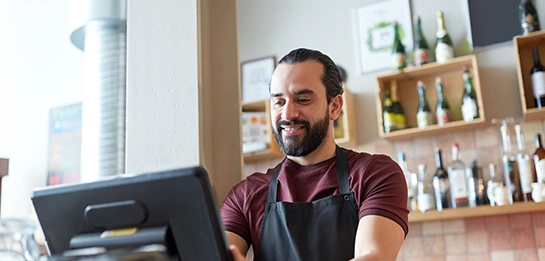 Man smiling working at a POS station in a store
