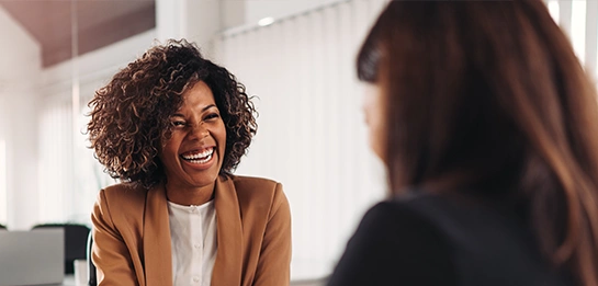 Woman laughing happily talking with her banker