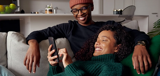Couple looking at smartphone laughing