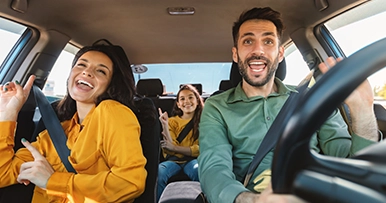 family enjoying road trip in their new car