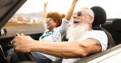 senior couple driving a convertible