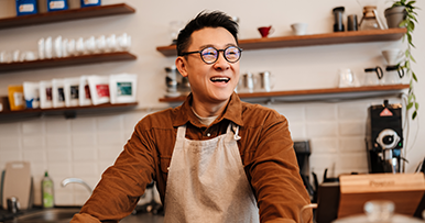 business owner employee at a cafe laughing and smiling