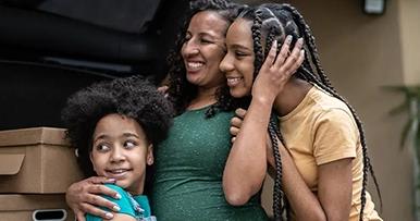 credit builder mother and two kids packing car for road trip