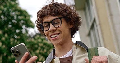 Young man smiling at his mobile phone