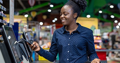 woman purchasing grocheries with her phone digital wallet mobile pay