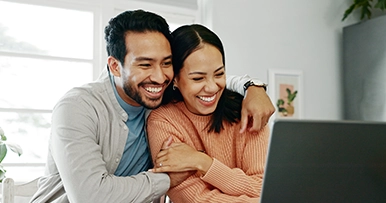 Couple celebrating good financial news at their computer