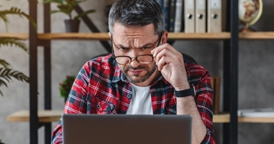 man viewing his computer laptop screen suspiciously