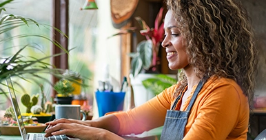 A small business owner typing on a laptop