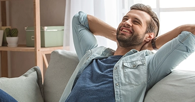 man relaxing on his couch at home living room