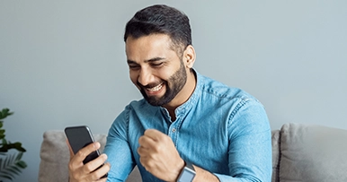 man looking at mobile device excited and happy