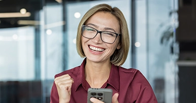 smling happy woman with glasses holidng mobile phone