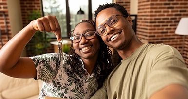 A happy couple holding keys to their new house