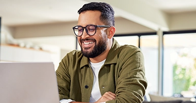 Man smiling looking at his laptop