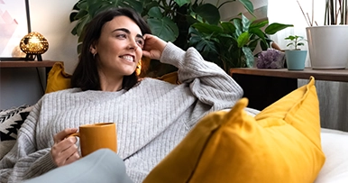 Women holding a mug and smiling while looking into the distance