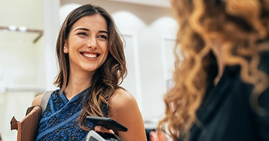 Woman smiling paying with her phone tap-to-pay