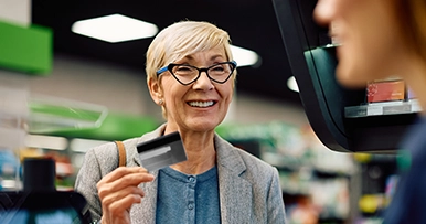 Senior woman holding a debit card at checkout