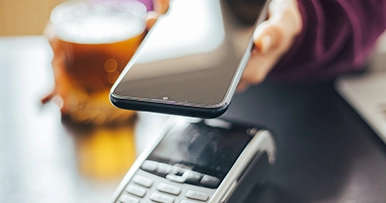 Close up of a smart phone paying with tap-to-pay