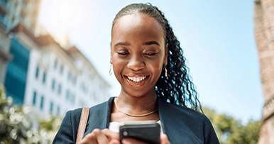 Young woman smiling, using her smartphone