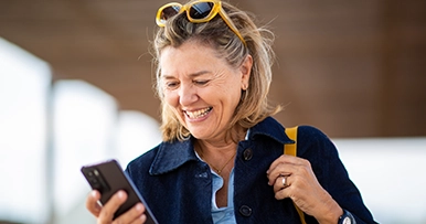 adult woman smiling at a text from a family member