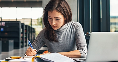 young woman studying at the library college campus