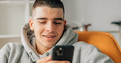 young man looking at phone on couch