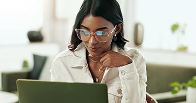 Young woman with glasses working at a laptop